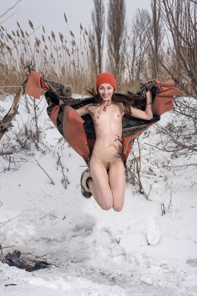 16P A adolescente sexy Selin fica nua com um gorro e botas perto de uma fogueira na neve