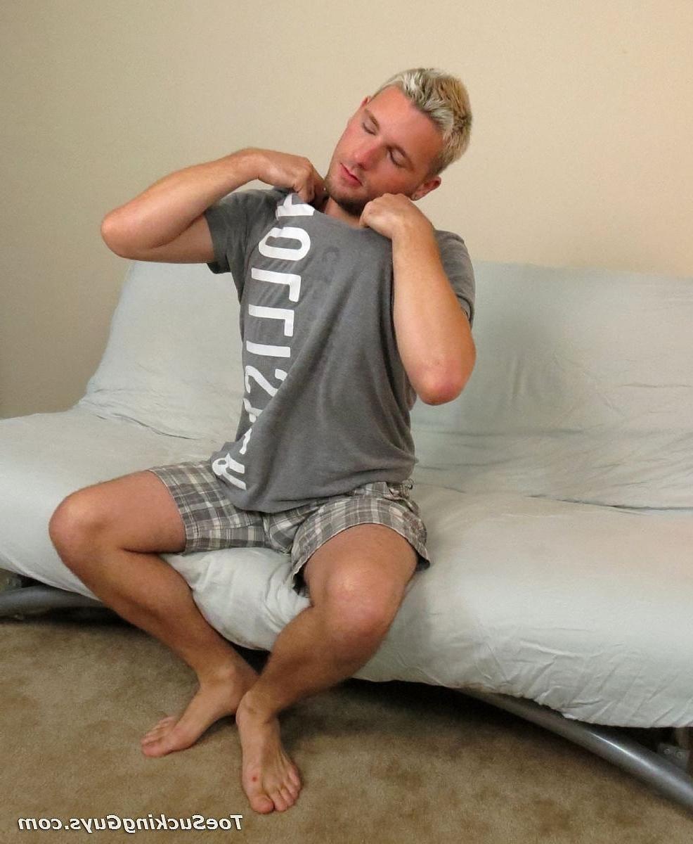 20P L'étalon blond Jason Lee masse ses pieds sexy et éjacule dessus sur le canapé.