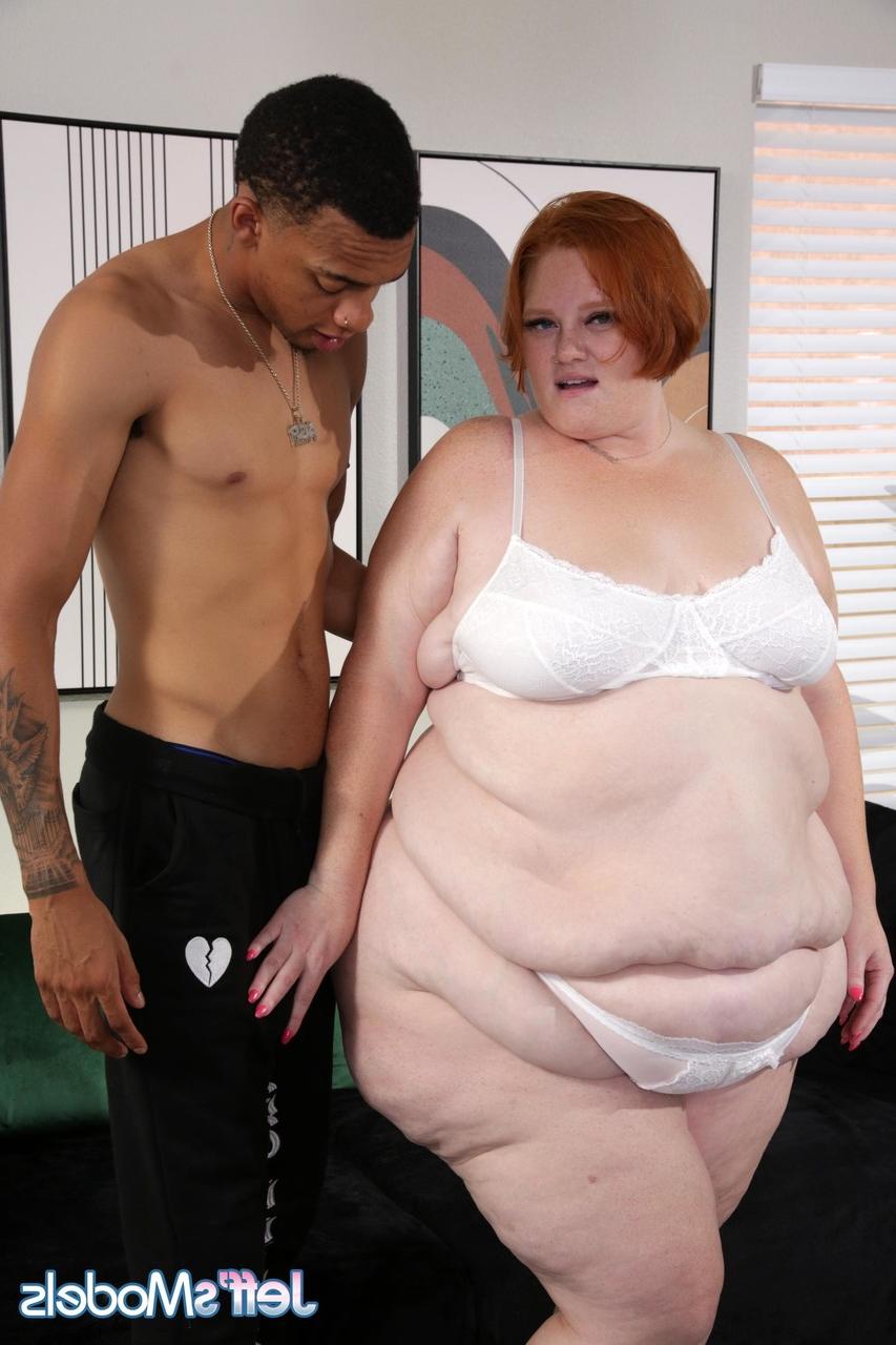 20P La belle rousse Julie Ginger se fait baiser en levrette par un black maigre.