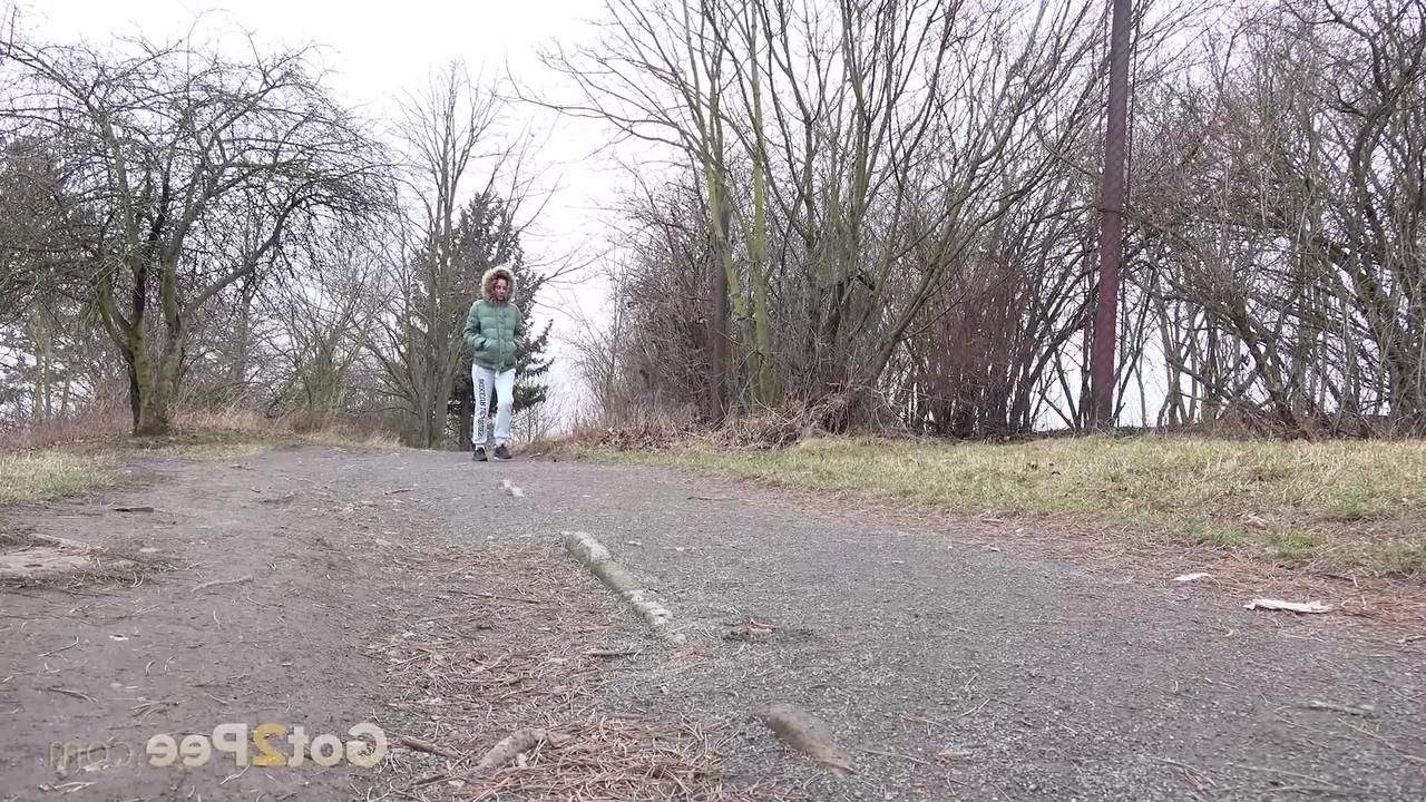 15P Ali Bordeaux faz xixi ao lado de uma trilha enquanto veste um casaco de inverno