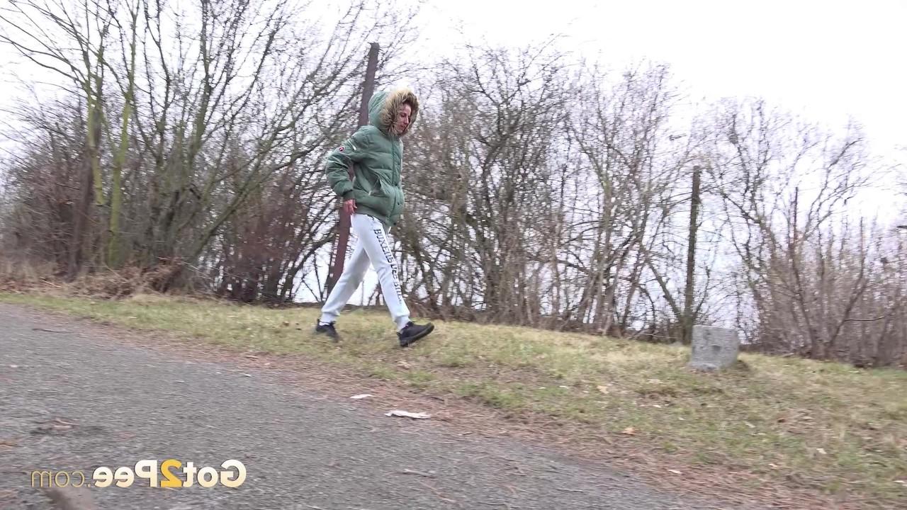 15P Ali Bordeaux faz xixi ao lado de uma trilha enquanto veste um casaco de inverno