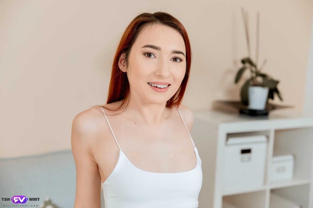 20P Sexy redhead Angie A strips and fingers her horny pussy on the couch