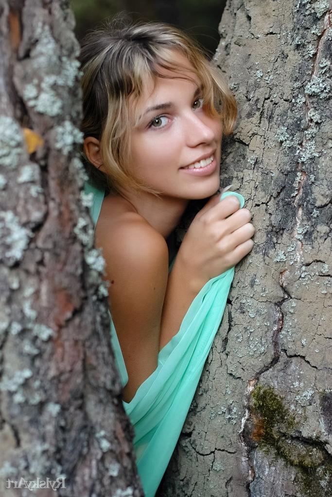 16P A encantadora adolescente loira Natalia B posa nua contra uma velha árvore
