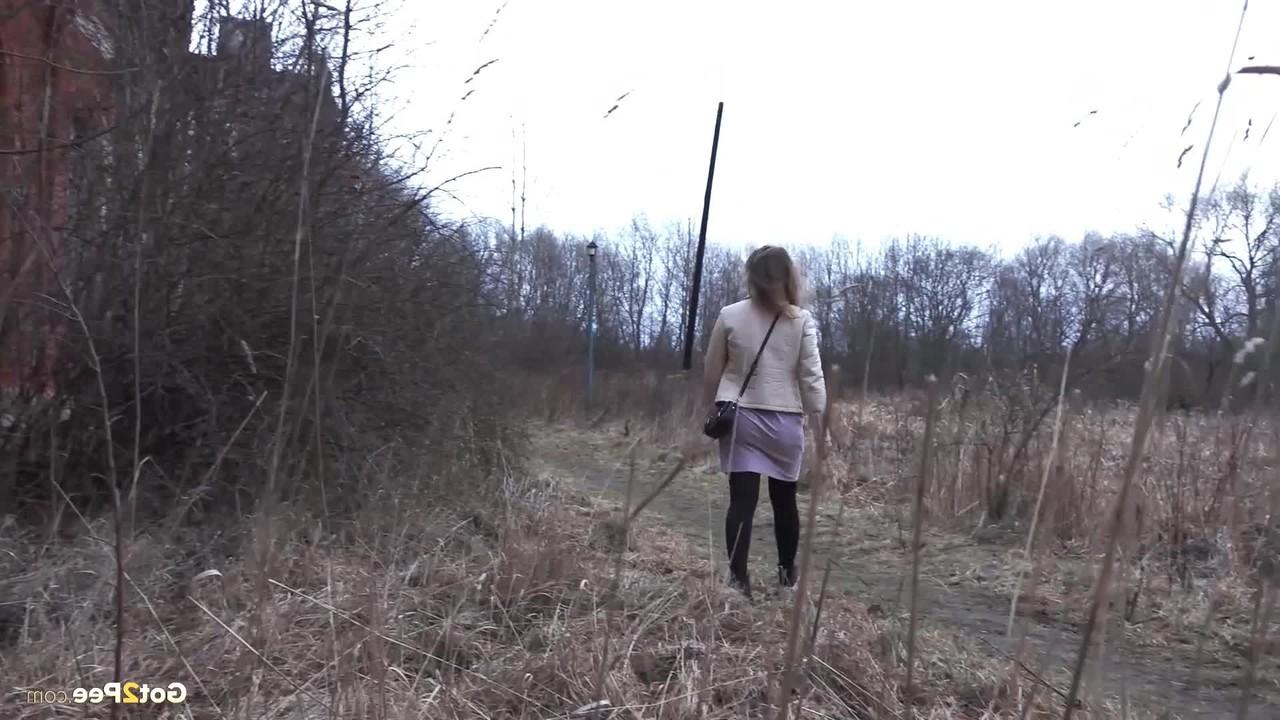 15P Rita, une petite fille prise, s'accroupit pour pisser derrière un immeuble à la campagne.