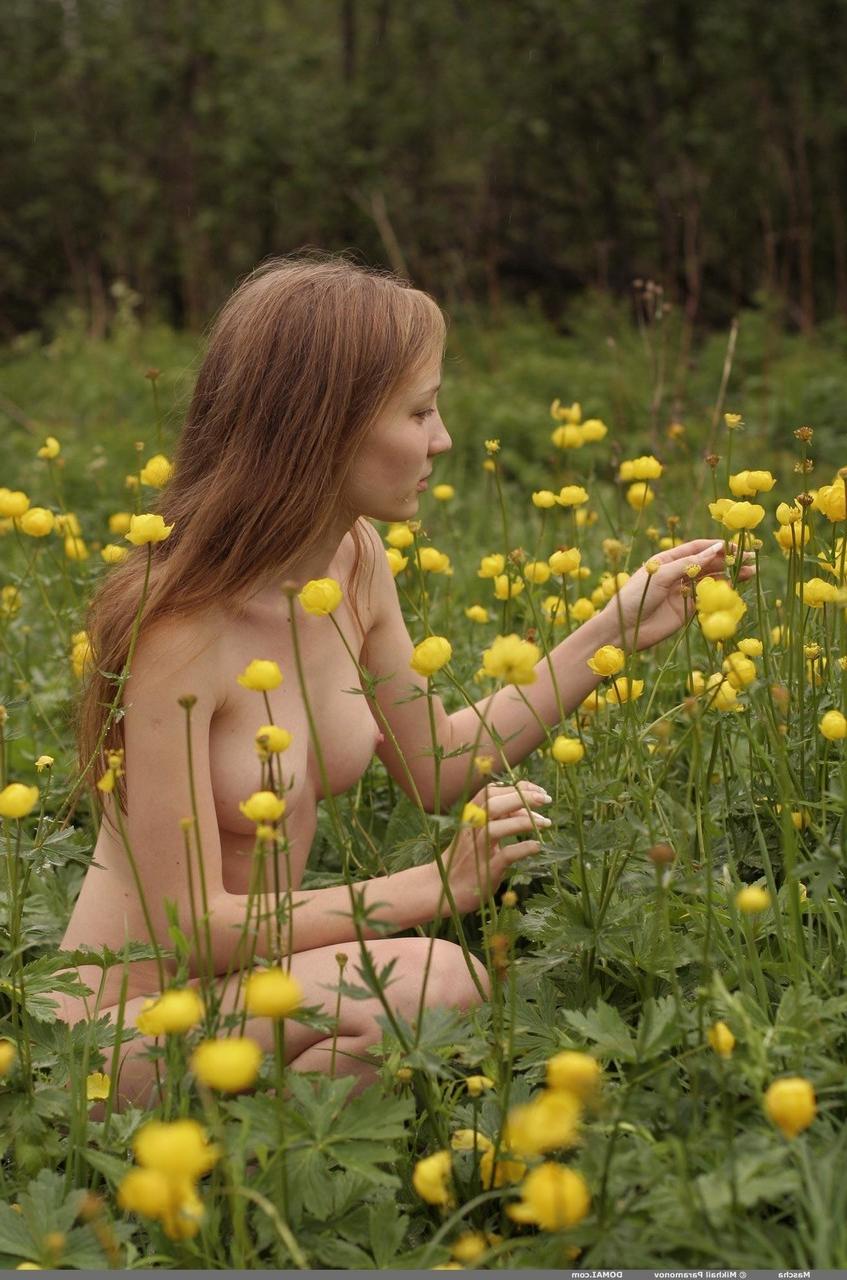 17P Una chica blanca y delgada deambula desnuda mientras recoge una corona de flores silvestres