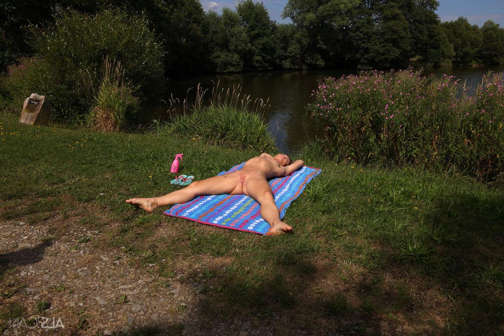 16P La jeune brune Zuzu Sweet pisse après s'être nue près d'un lac.