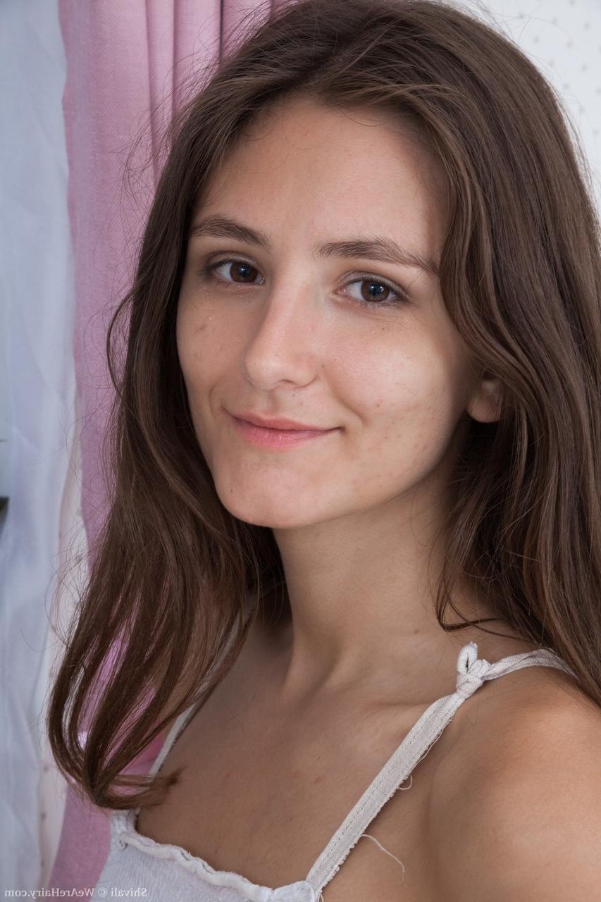 18P Garota morena sozinha mostra suas axilas com barba por fazer e sua vulva em seu quarto