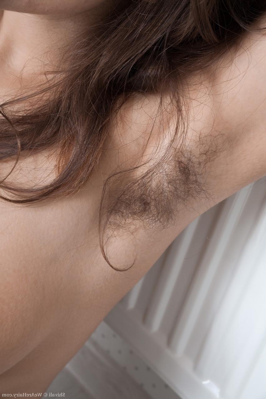 18P Garota morena sozinha mostra suas axilas com barba por fazer e sua vulva em seu quarto