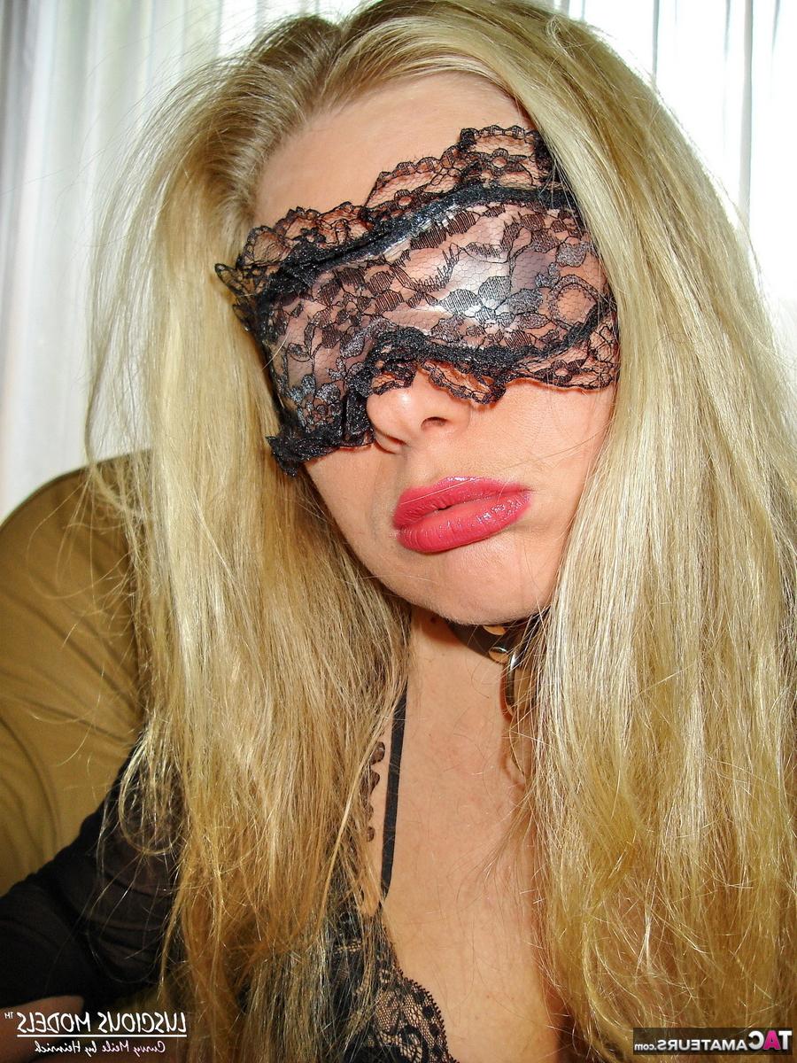 16P Loira amadora segura os seios antes de colocar uma máscara em lingerie preta