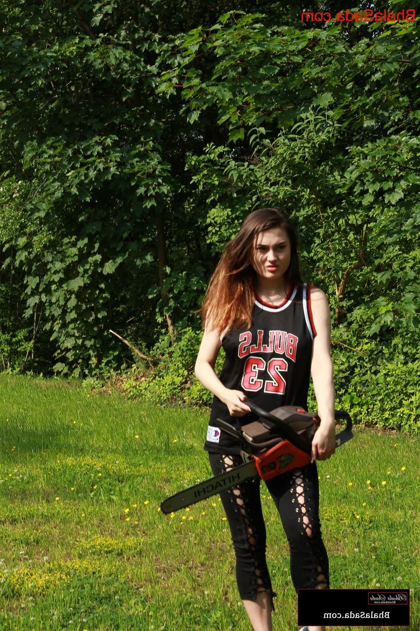 15P La morena Bhala Sada posa con su traje sexy y una motosierra en las manos.