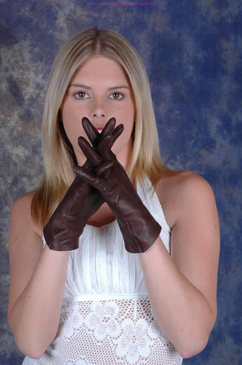 15P Mujer rubia se pone guantes de cuero marrón mientras usa un vestido blanco