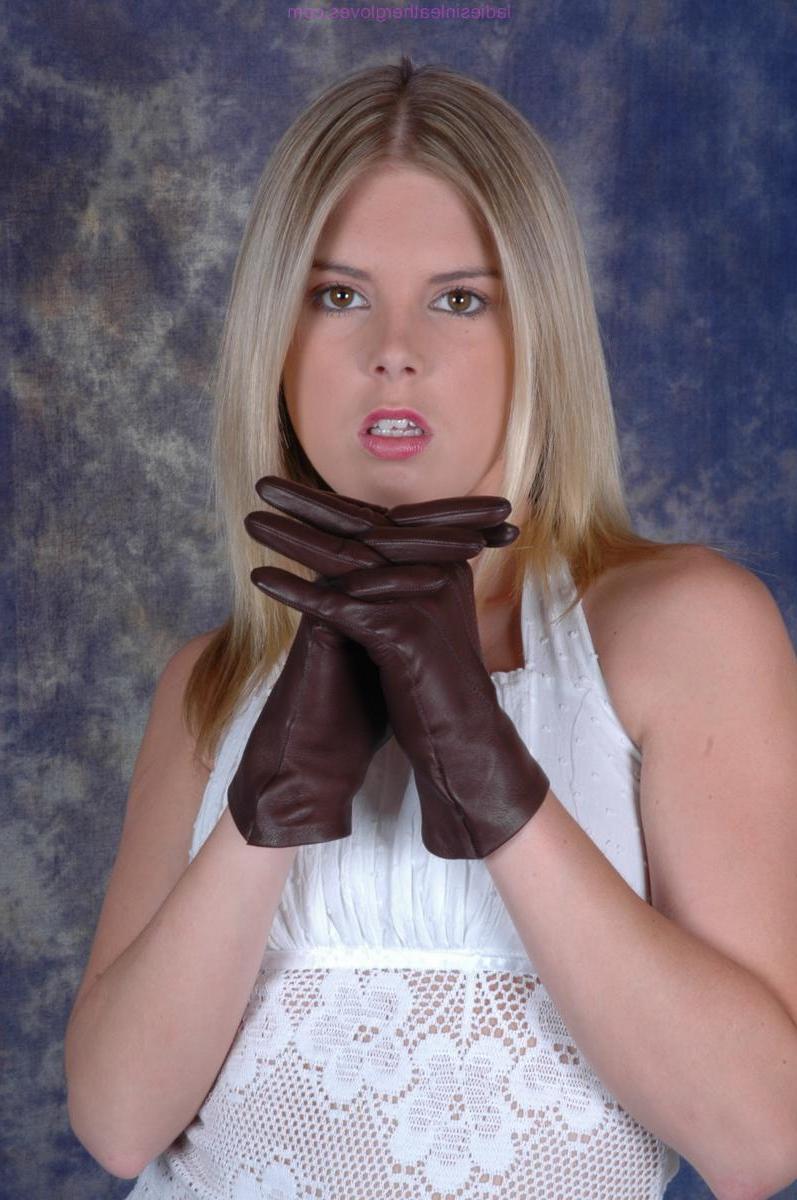 15P Mujer rubia se pone guantes de cuero marrón mientras usa un vestido blanco