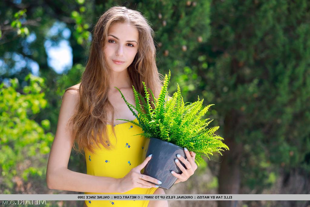18P La joven delgada Elle Tan se desnuda totalmente en la pared de un jardín