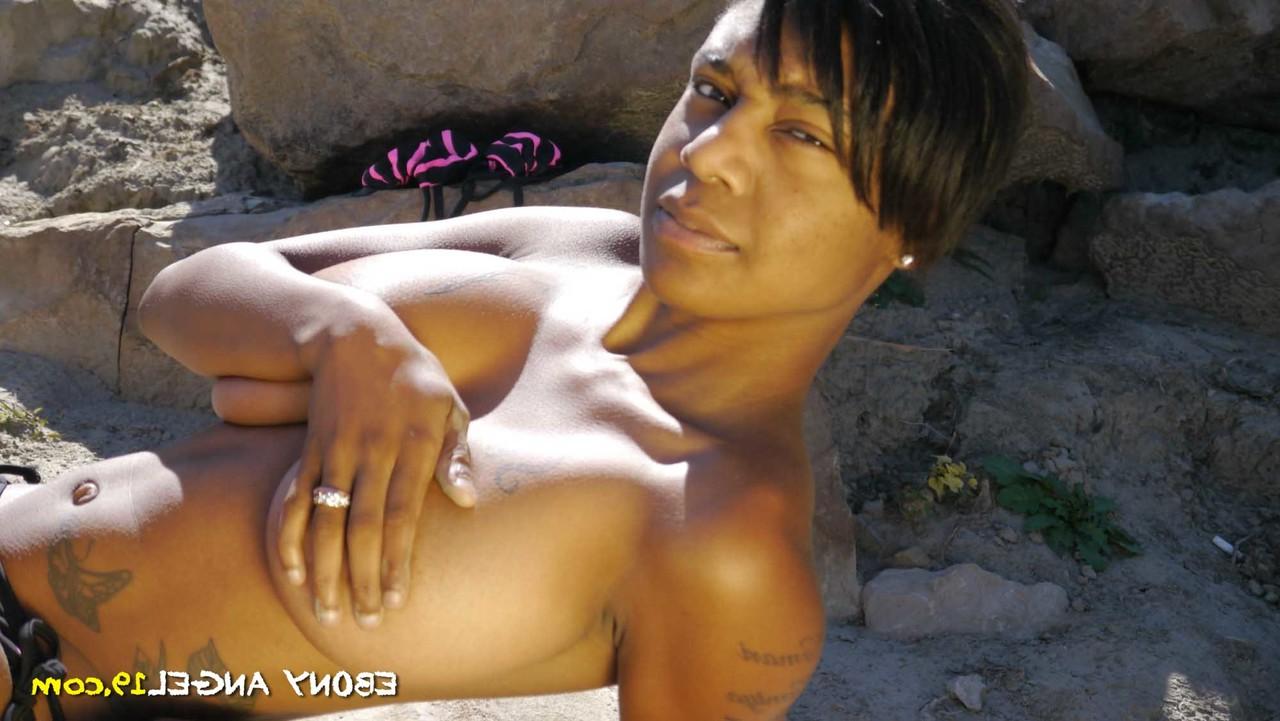 16P Short-haired Ebony Angel flaunts her big tits while posing topless outdoors