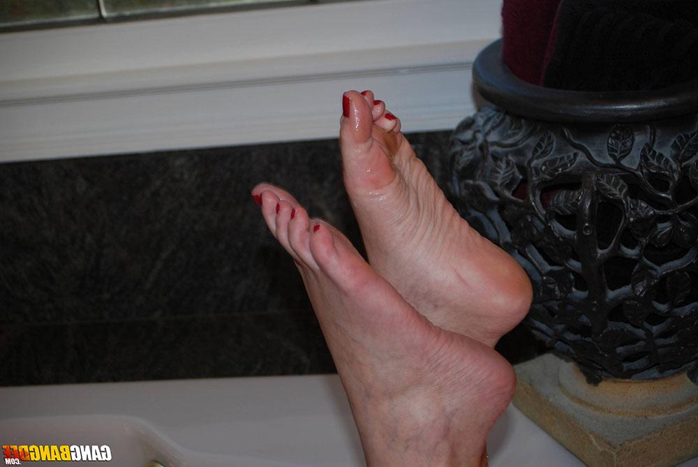 15P Middle-aged redhead Dee Delmar takes a cumshot on her soles in a bathtub