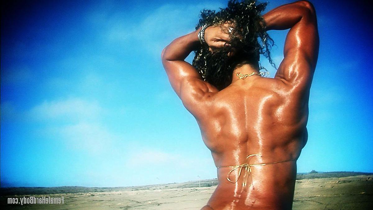 15P O fisiculturista negro Alexis Ellis flexiona ao ar livre em um biquíni minúsculo