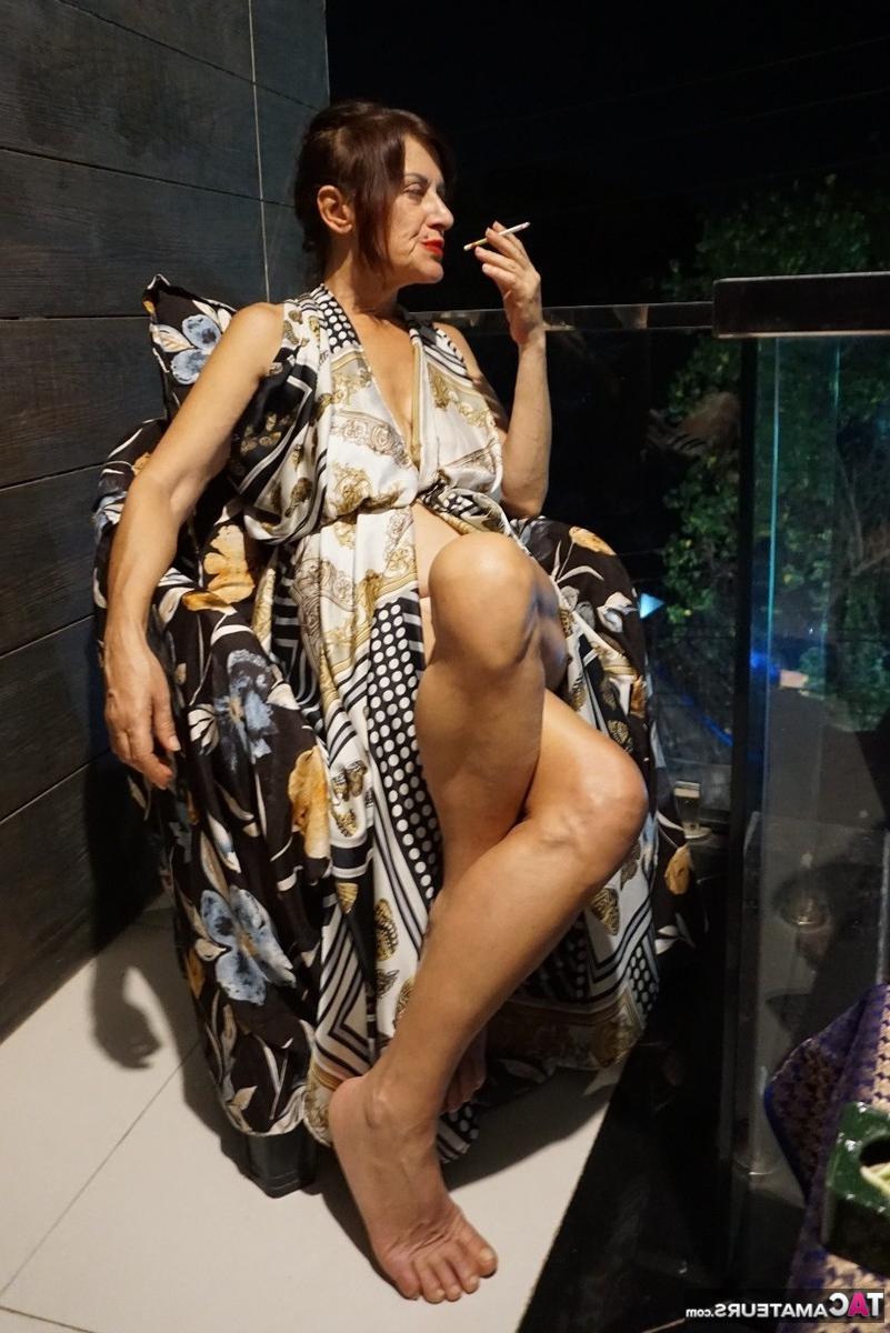 16P La brune mature Diana Ananta se frotte les pieds nus en fumant.