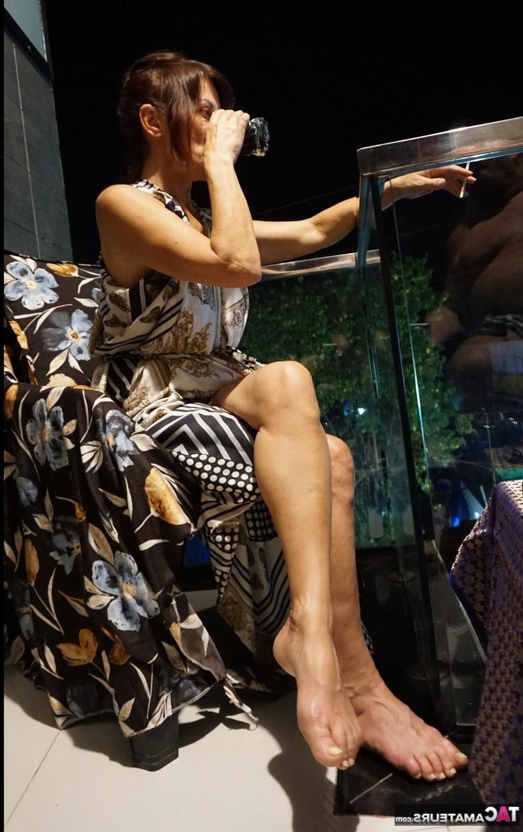 16P La brune mature Diana Ananta se frotte les pieds nus en fumant.