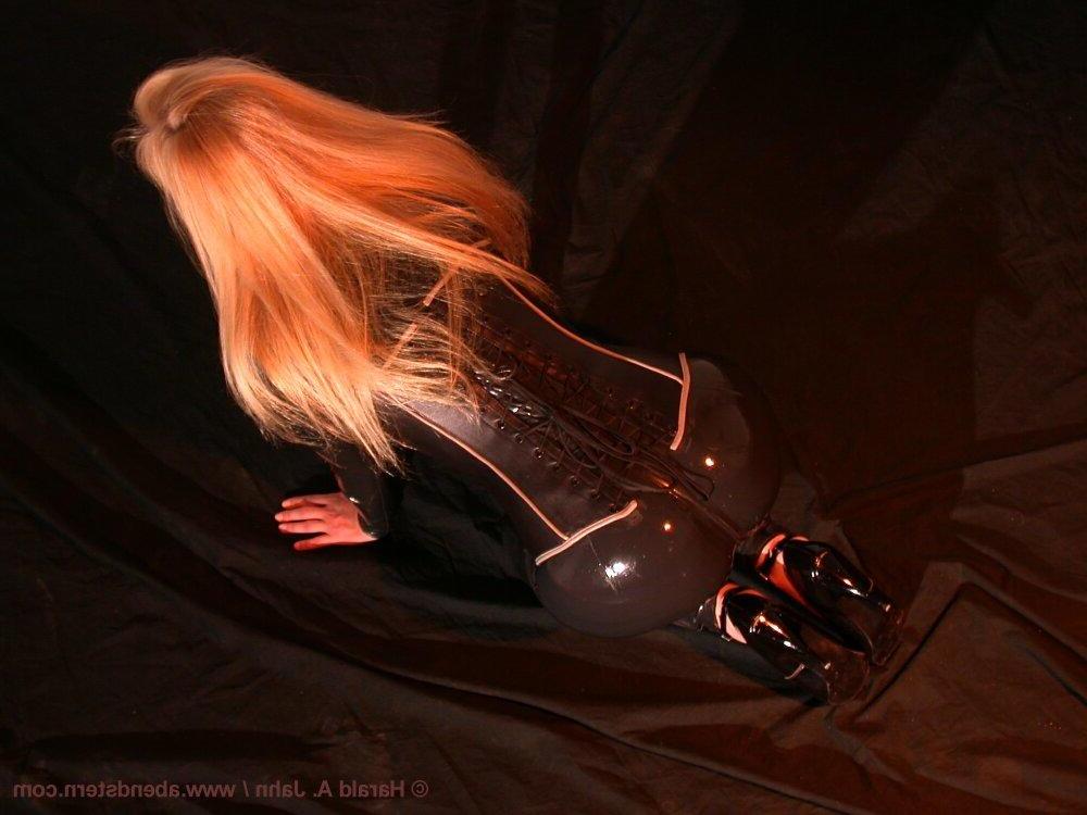 16P Natural blonde finds herself restrained to a glass table in latex clothing