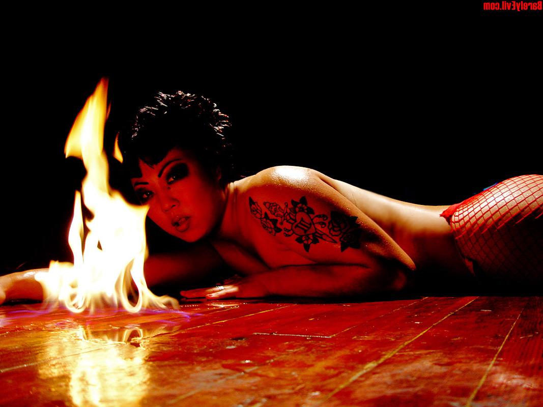16P Masuimi Max, une asiatique tatouée, se met seins nus à côté de flammes.