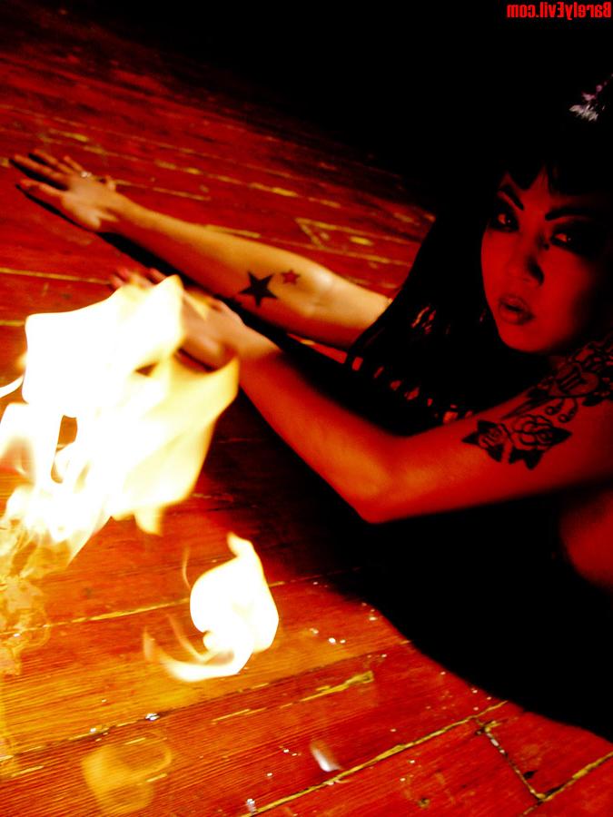 16P Masuimi Max, une asiatique tatouée, se met seins nus à côté de flammes.