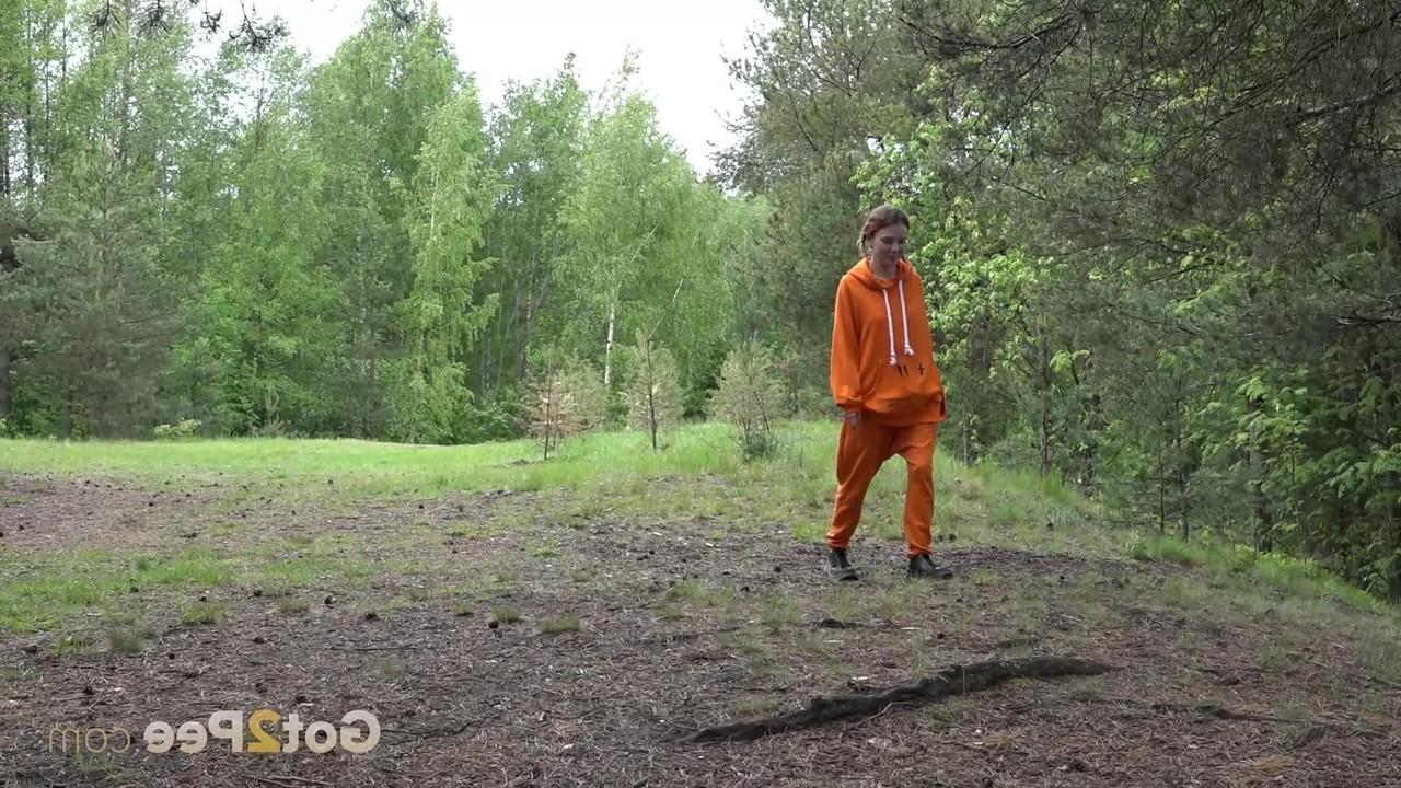 15P La jolie fille Jeanna se fait surprendre en train de pisser dans les bois contre un arbre.