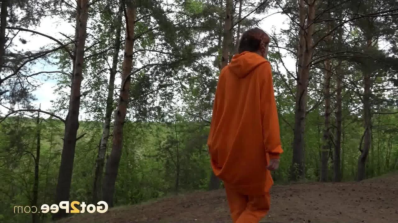 15P La jolie fille Jeanna se fait surprendre en train de pisser dans les bois contre un arbre.