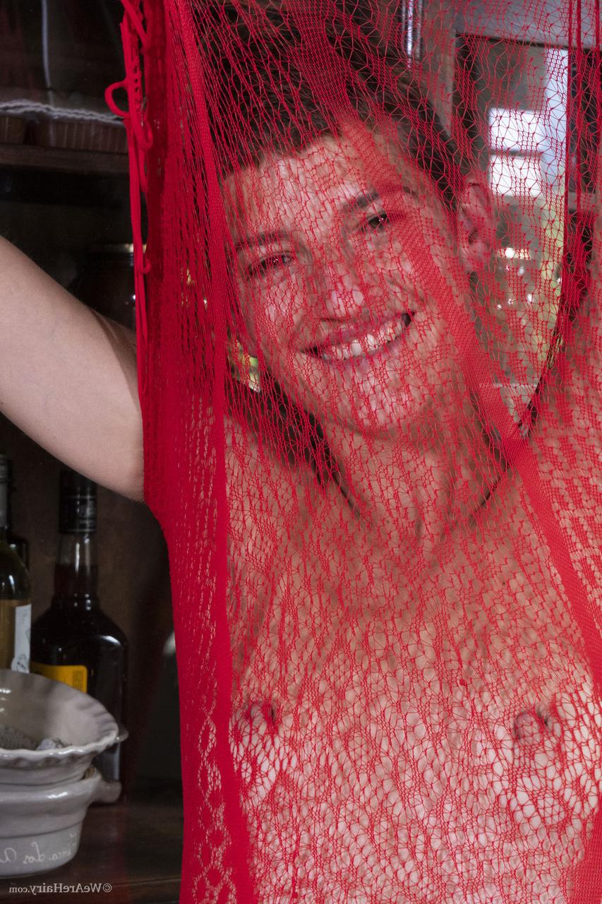 20P Short haired babe Gloria M removes her sheer lacy dress & rubs her bushy cunt