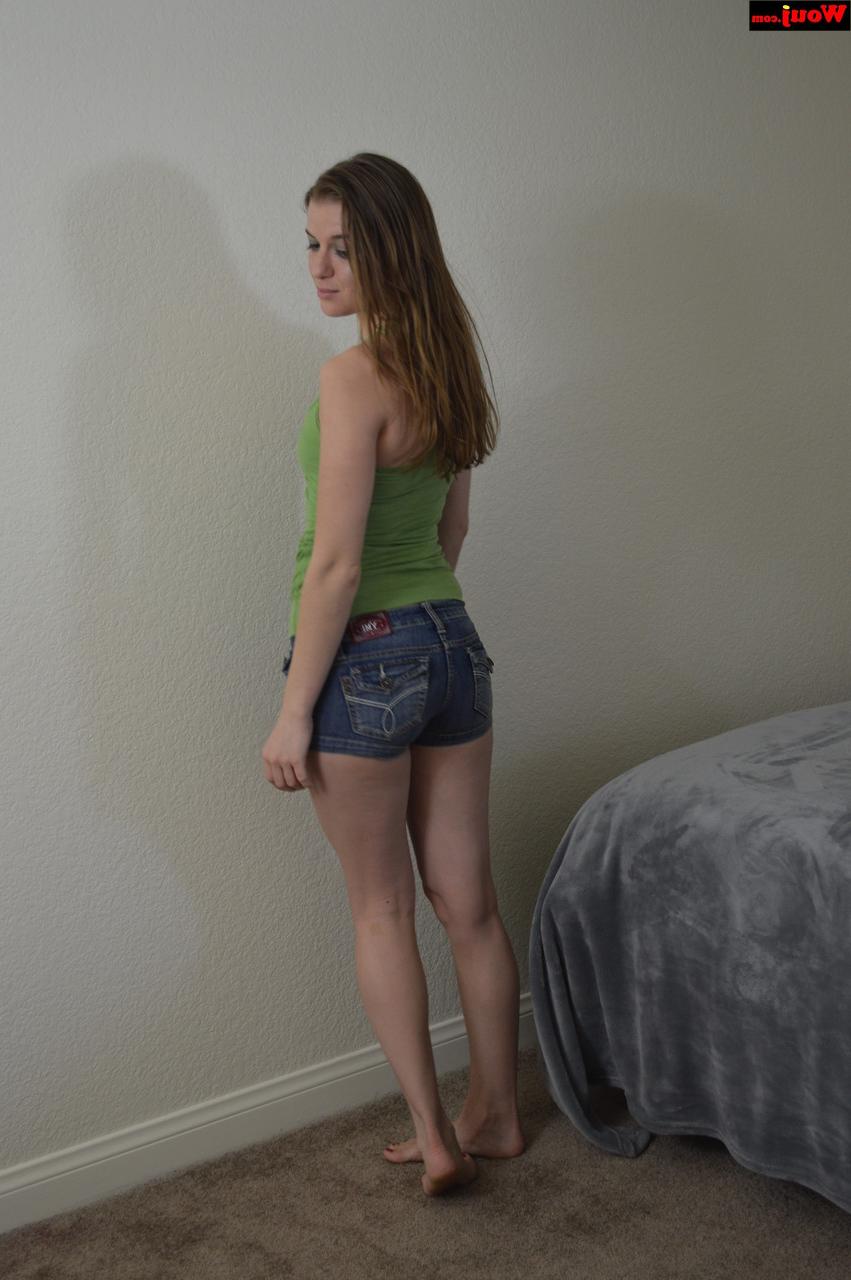 15P Linda adolescente amadora posando com uma camisa verde e shorts jeans sexy