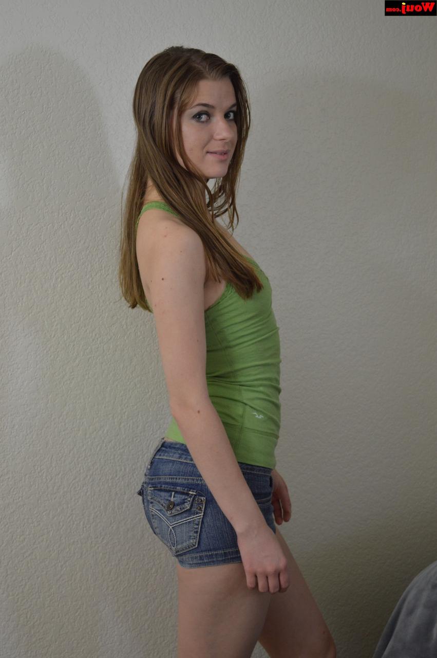 15P Linda adolescente amadora posando com uma camisa verde e shorts jeans sexy