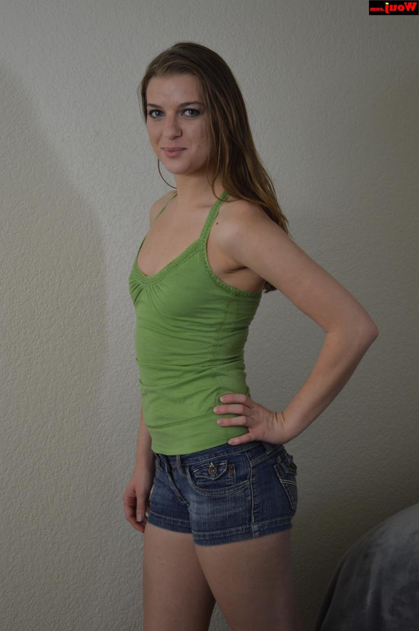 15P Linda adolescente amadora posando com uma camisa verde e shorts jeans sexy