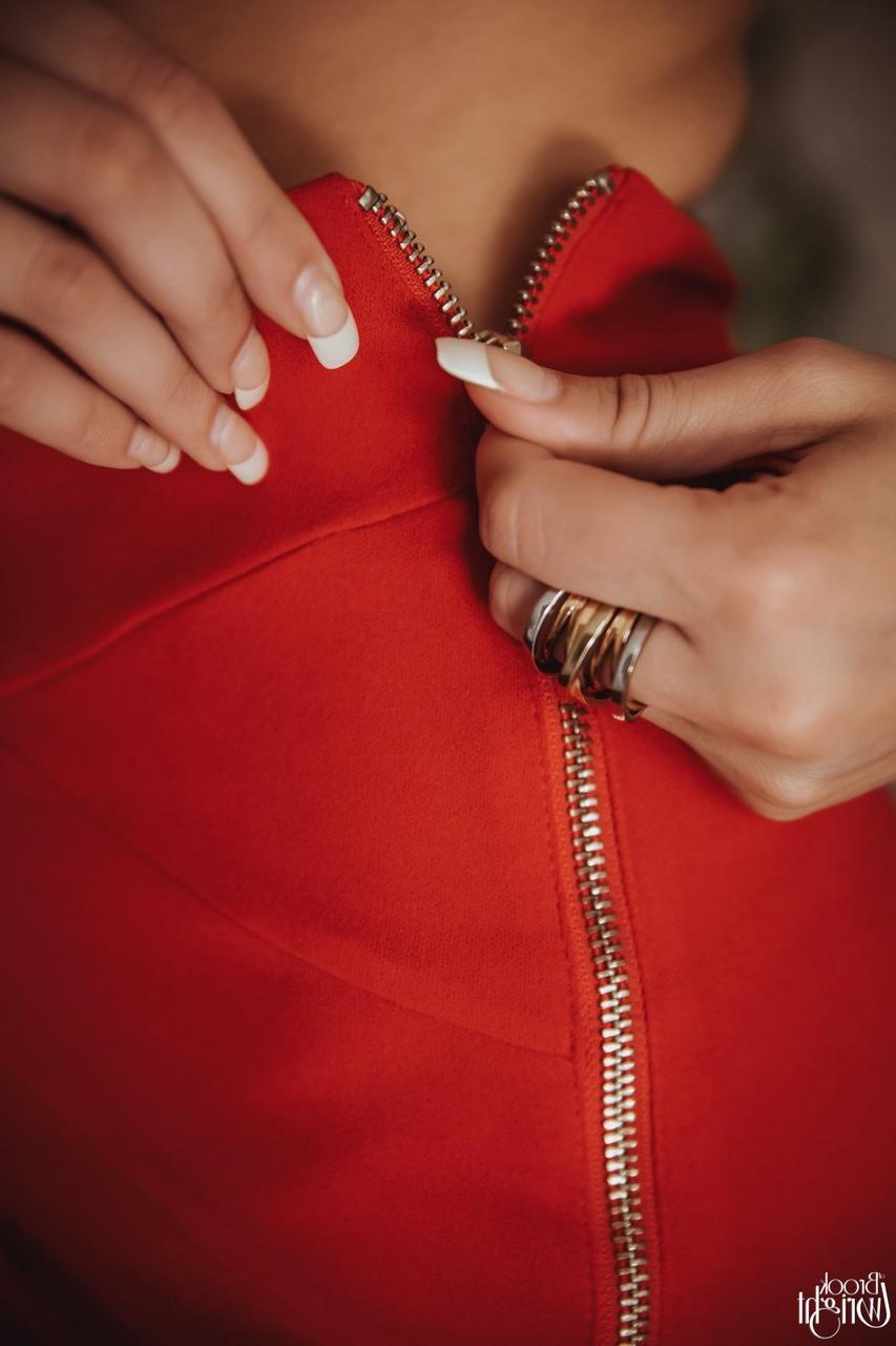 12P Hot brunette Brook Wright unzips a red skirt to pose nude afore a mirror