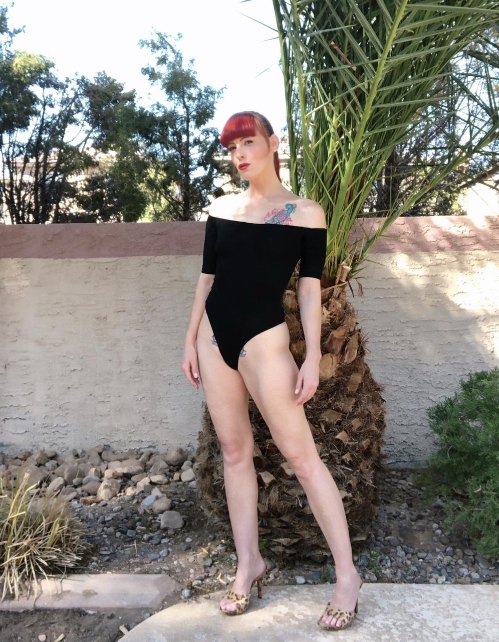 18P La pelirroja caliente Nikki Rouge posa con su traje negro y muestra sus pies sexys