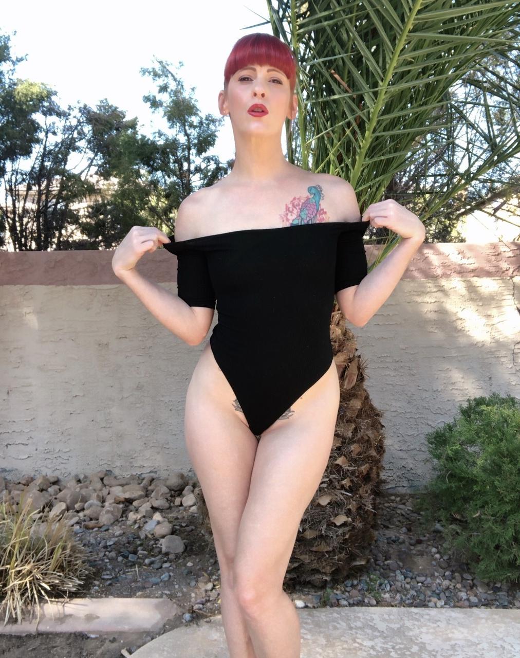 18P La pelirroja caliente Nikki Rouge posa con su traje negro y muestra sus pies sexys