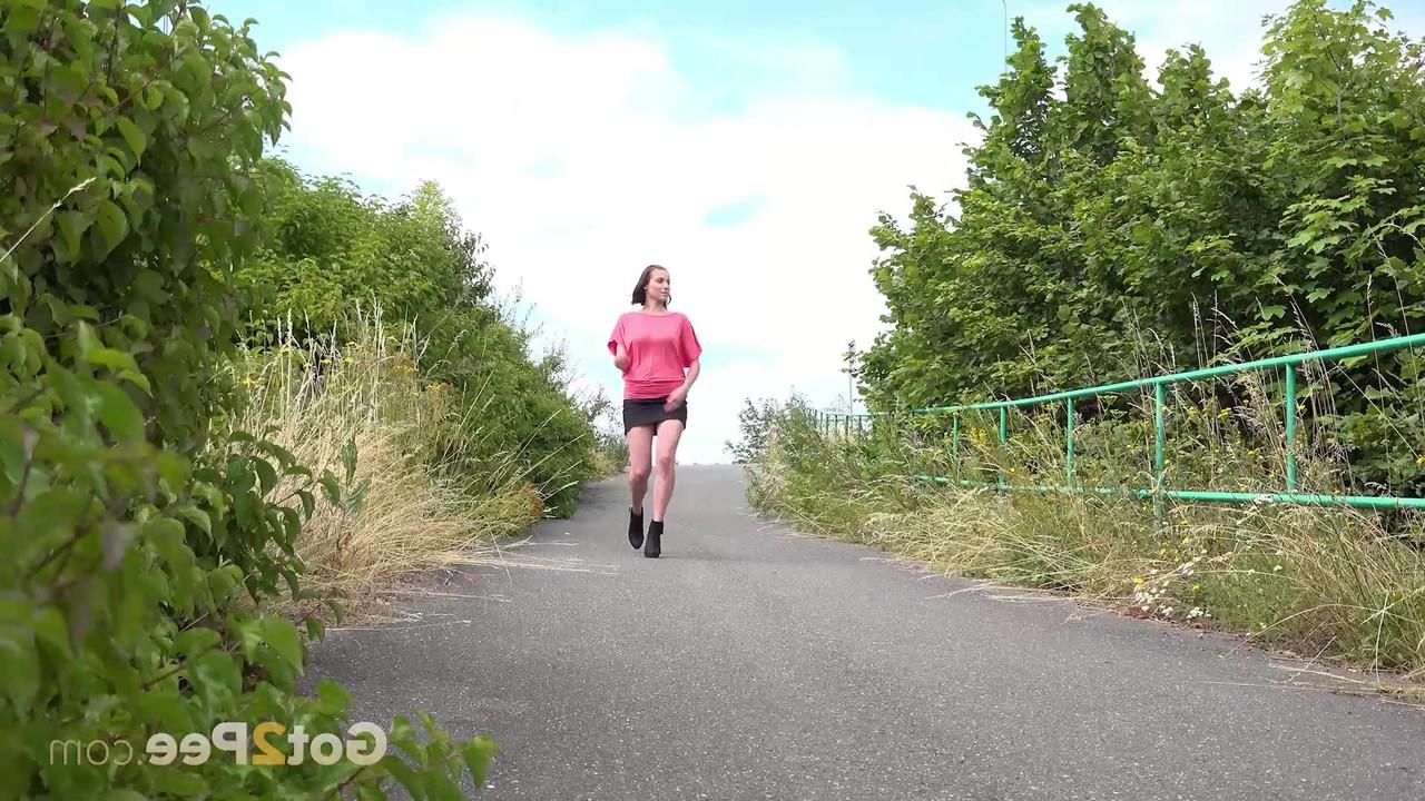 15P Caucasian girl Vicoria Daniels pisses on a paved path while out for a walk