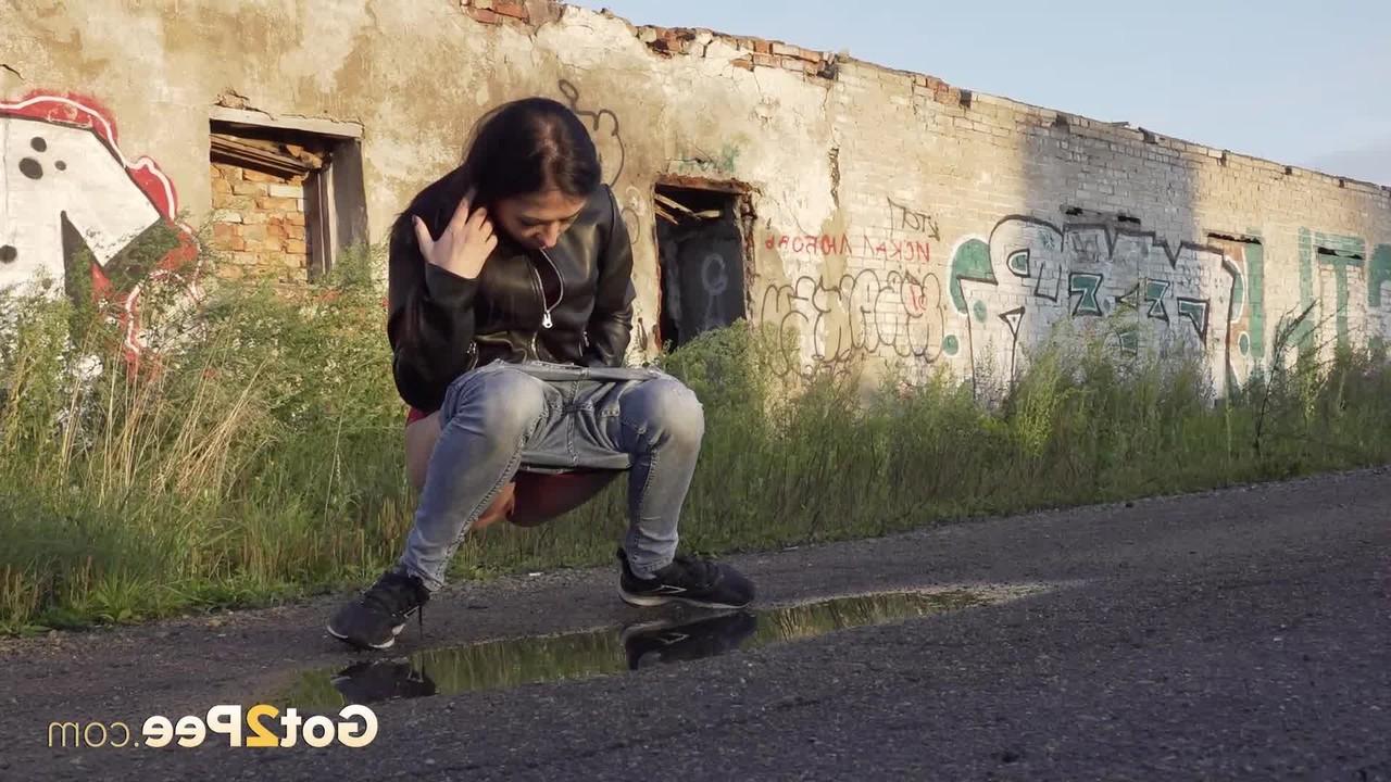 15P Petite brunette Natasha squats for a piss in a puddle on a gravel road
