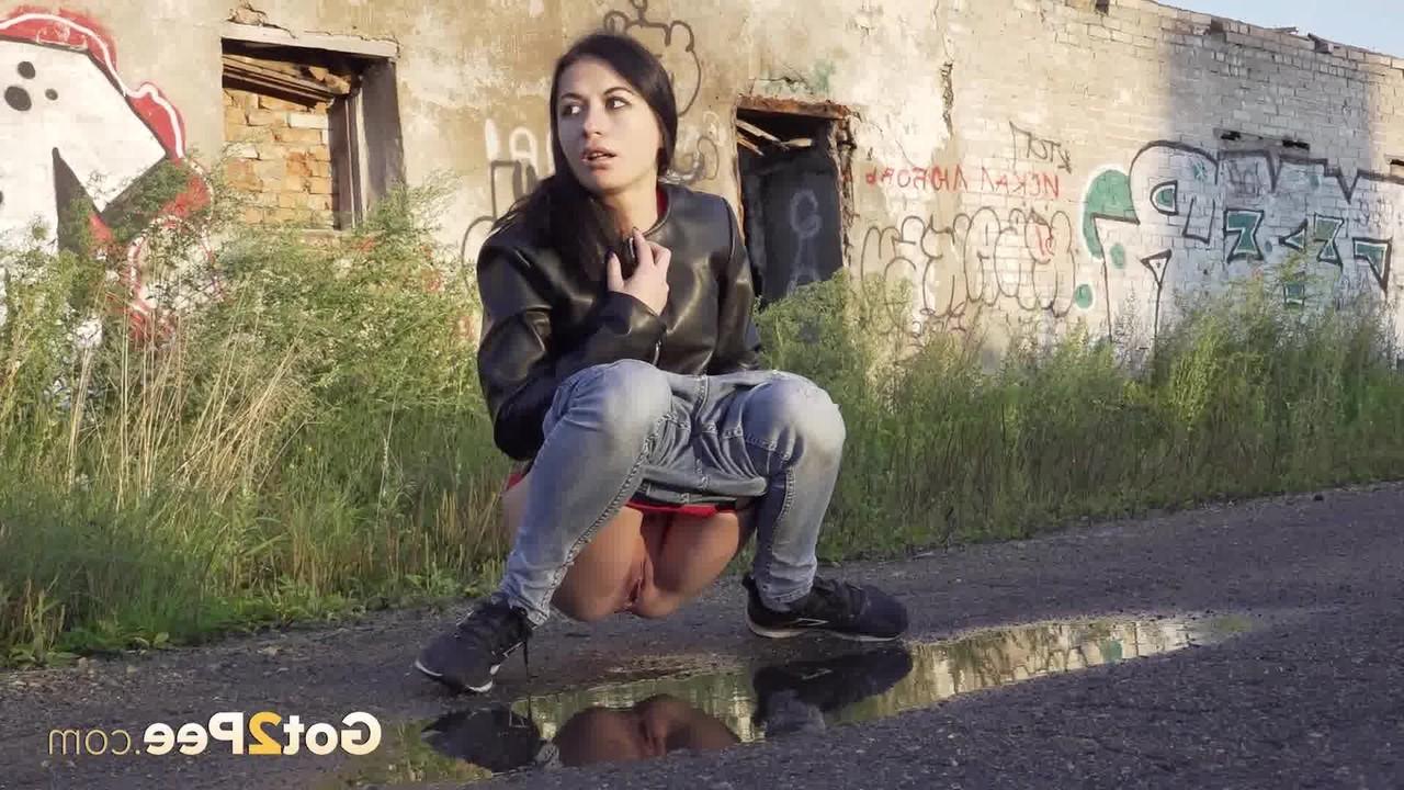 15P Petite brunette Natasha squats for a piss in a puddle on a gravel road