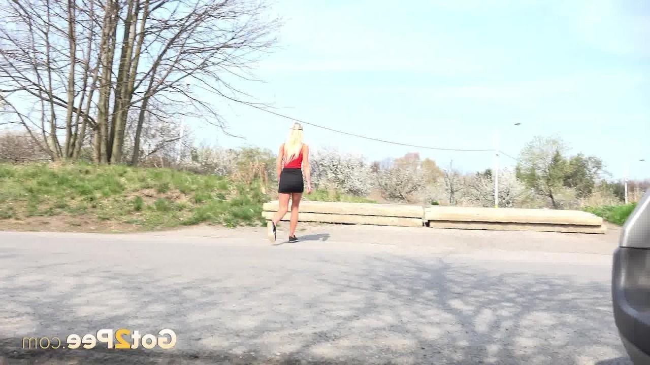 15P A loira Claudia Macc fica ao lado de uma estrada pavimentada enquanto mija
