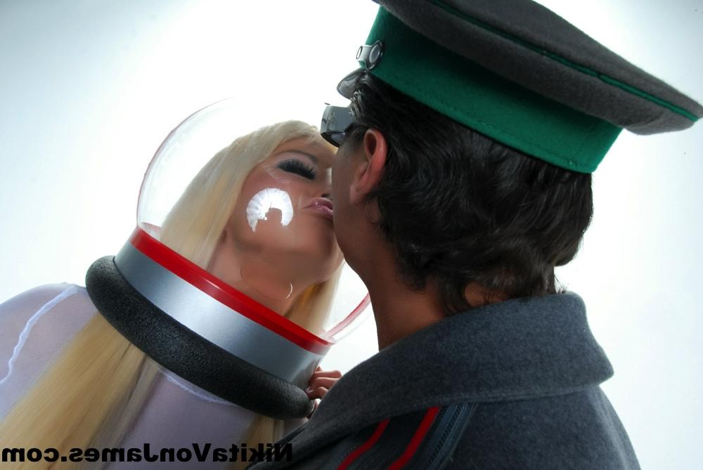 16P Hot blonde Nikita Von James models futuristic apparel next to a military man
