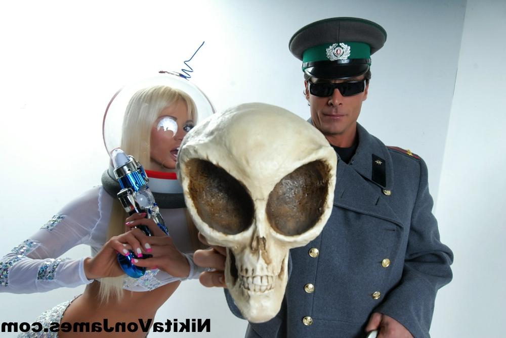 16P Hot blonde Nikita Von James models futuristic apparel next to a military man