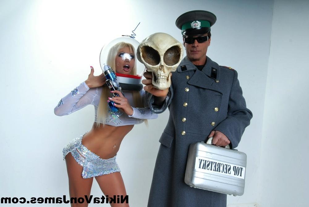 16P Hot blonde Nikita Von James models futuristic apparel next to a military man