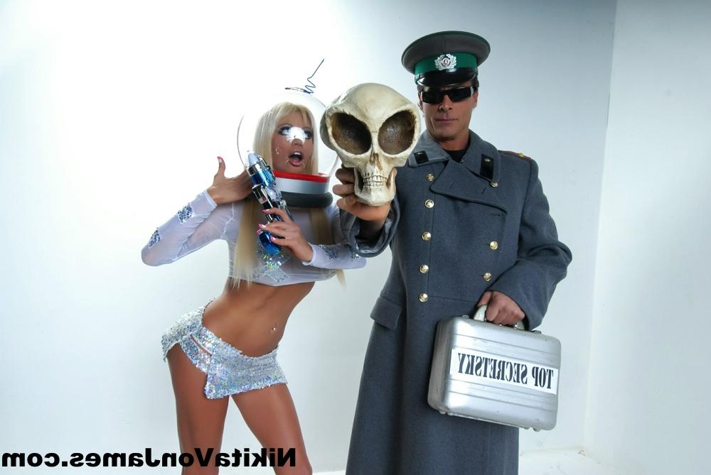 16P Hot blonde Nikita Von James models futuristic apparel next to a military man