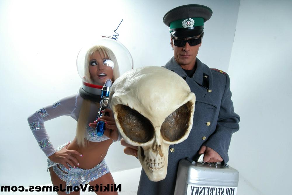 16P Hot blonde Nikita Von James models futuristic apparel next to a military man