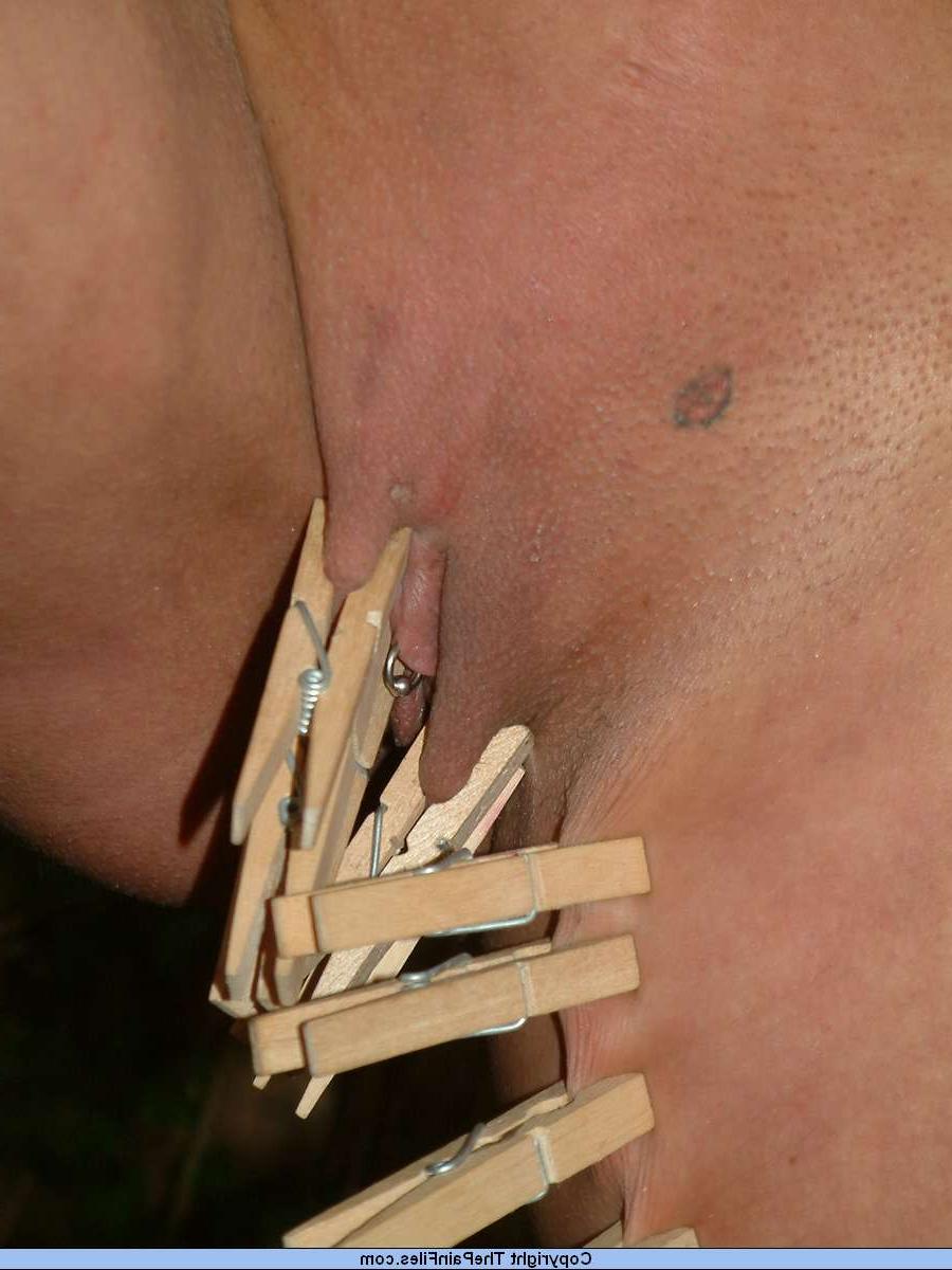16P Menina nua é fixada com uma mordaça de bola e prendedores de roupa enquanto está amarrada a uma árvore