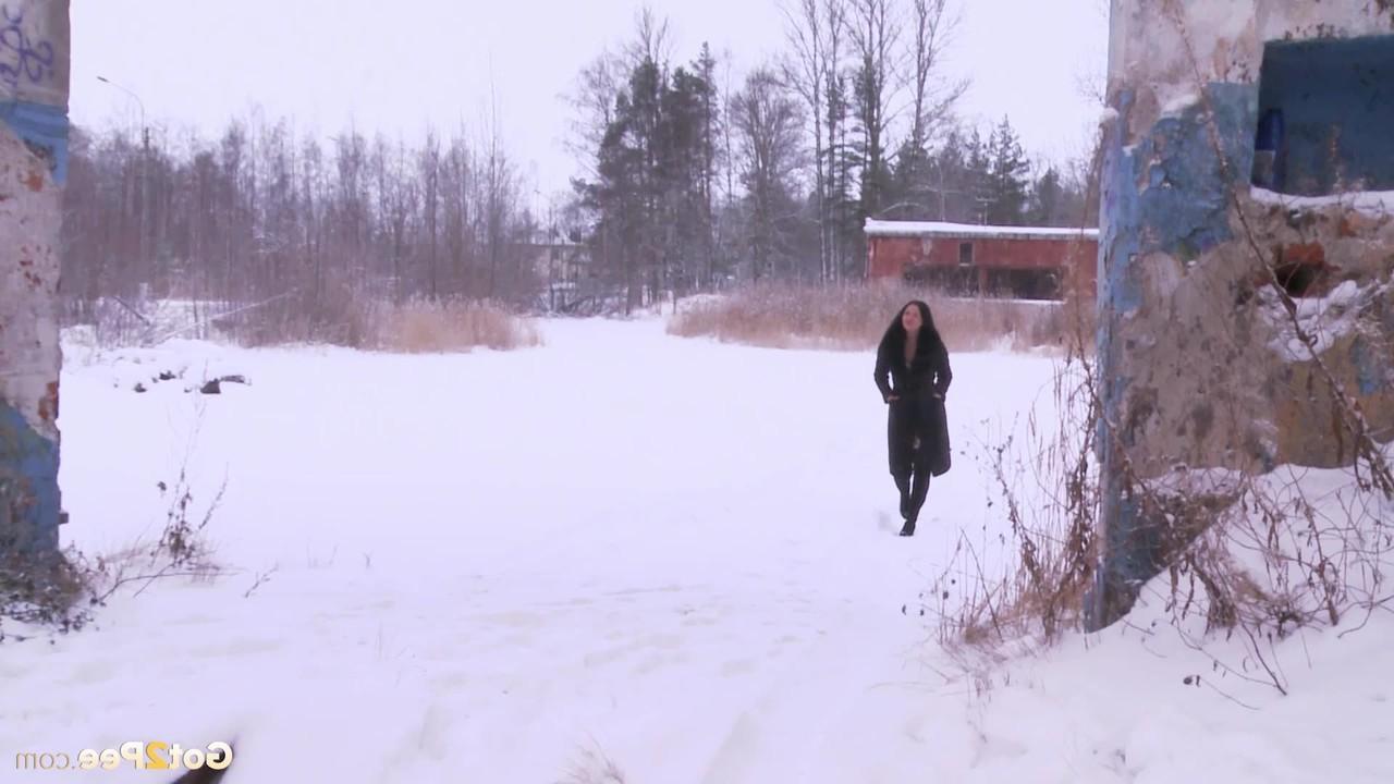 15P Die dunkelhaarige Frau Dasha enthüllt ihre rasierte Muschi, während sie in den Schnee pinkelt