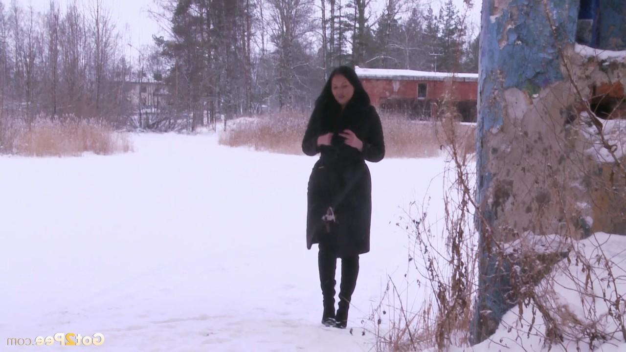 15P Die dunkelhaarige Frau Dasha enthüllt ihre rasierte Muschi, während sie in den Schnee pinkelt