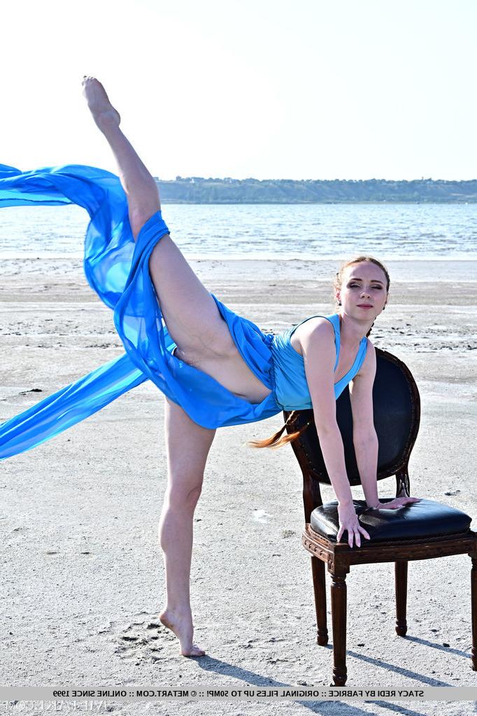 18P Die flexible Teenagerin Stacy Redi zieht sich auf einem Stuhl am Strand völlig aus