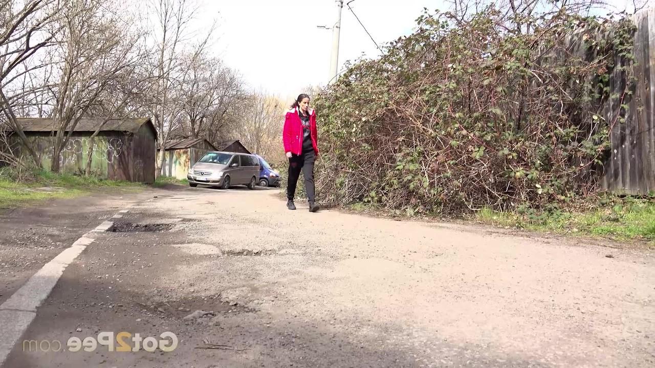 15P Caucasian female Ali Bordeaux squats for a piss against a wooden fence