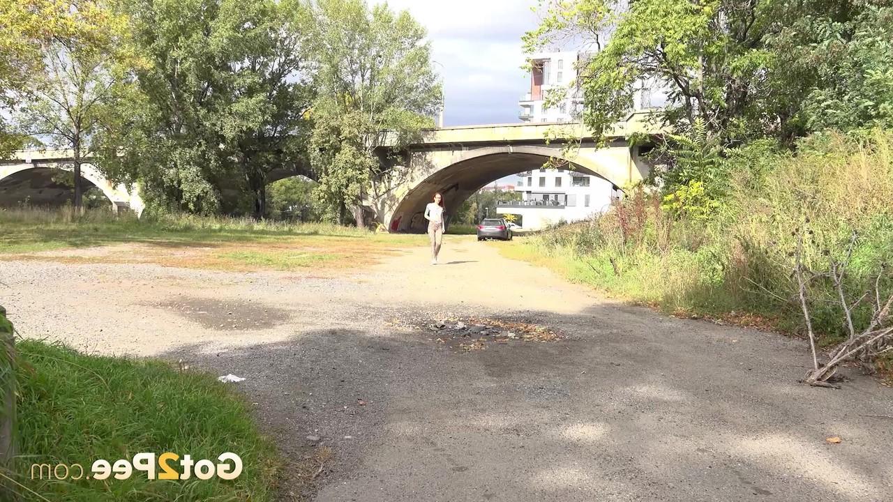 15P A ruiva Sandra faz xixi em uma poça em uma estrada de cascalho