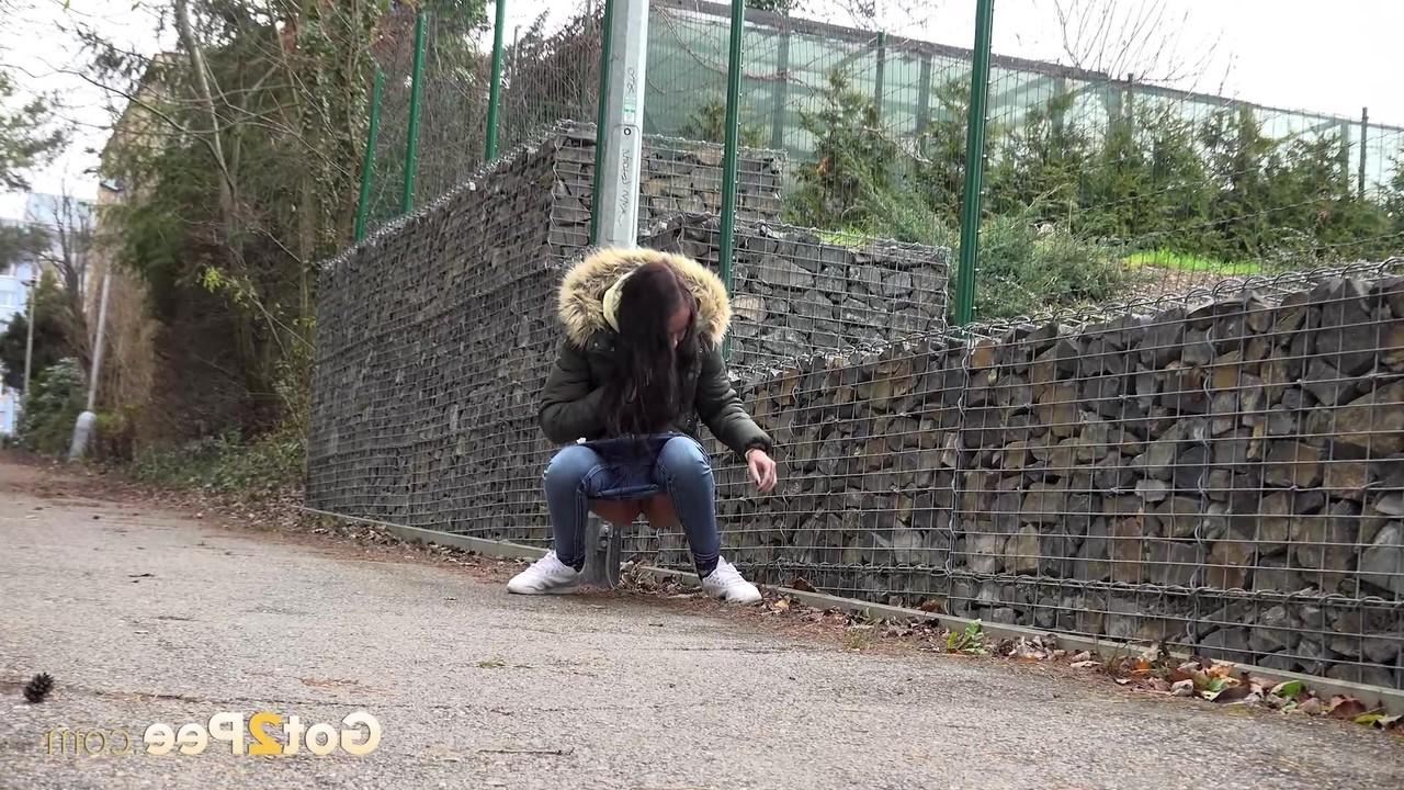 15P Brunette girl Mistika gets caught with her pants down while peeing on a road